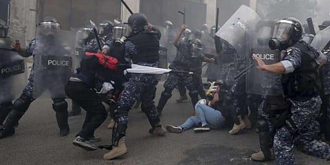 Policemen beat anti-government protesters during a protest near Parliament Square, in Beirut, Lebanon. (File Photo | AP)