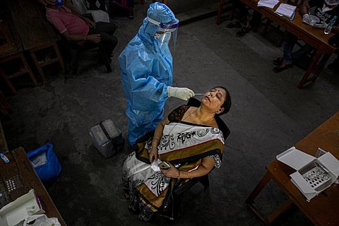 An Indian health worker takes a nasal swab sample of a teacher to test for COVID-19 at a school before classes open in Gauhati, India, Wednesday, Sept. 2, 2020. (Photo | AP)