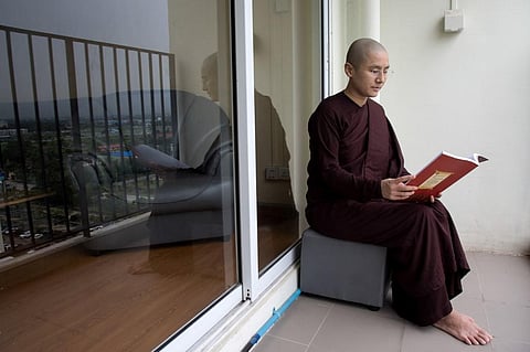 Myanmar Buddhist nun Ketumala reading a book at her apartment in Yangon. (Photo | AFP)