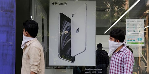 People walk past an image of an iPhone displayed at an Apple store in Ahmedabad. (File photo| AP)