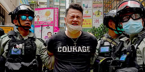 Police detain a protester after being pepper sprayed during a protest in Causeway Bay. (Photo | AP)