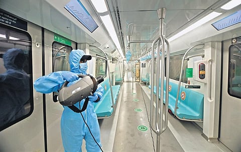 A worker disinfecting the interior of a Kochi Metro train at Muttom yard on Friday. Metro services will resume on Monday after a gap of five months | Arun Angela