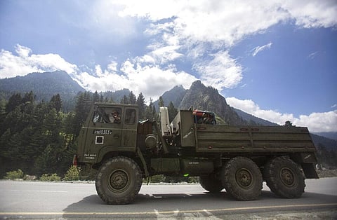 An Indian army soldier gestures towards the photographer as his convoy moves on the Srinagar- Ladakh highway. (Photo | AP)