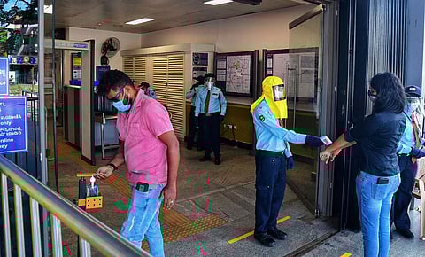 Metro staff in PPE screen passengers for fever at the entrance of Nadaprabhu Kempegowda Station. (Photo | Shriram BN, EPS)