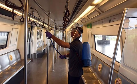 DMRC employees sanitise a coach during a media preview as the Delhi Metro network prepares to resume services partially. (Photo | Parveen Negi/EPS)