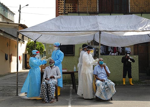 Sri Lankan municipal health workers take swab samples from residents to test for COVID-19 in Colombo. (Photo | AP)