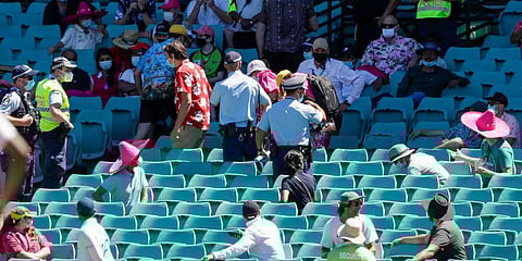 Police escort spectators from the stands during play on day four of the third cricket test between India and Australia at the Sydney Cricket Ground. (Photo | AP)