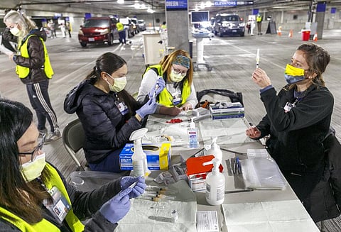 Medical professionals from Oregon Health & Science University load syringes with the Moderna COVID-19 vaccine at a drive-thru vaccination clinic in Portland. (Photo | AP)