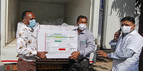 Workers unload packets containing Covishield vaccine on their arrival at the Civil Hospital in Ahmedabad Tuesday. (Photo | PTI)