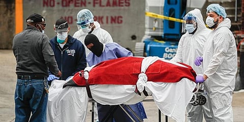 A body wrapped in plastic that was unloaded from a refrigerated truck is handled by medical workers wearing personal protective equipment at Brooklyn Hospital Center. (File Photo | AP)