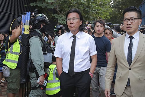 In this Monday, Nov. 25, 2019 photo, lawyer Daniel Wong Kwok-tung, center, arrives at the Polytechnic University to meet the protesters in Hong Kong. (File Photo | AP)