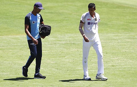 India's Navdeep Saini, right, walks with a trainer from the field after injuring his leg while bowling during play on the first day. (Photo | AP)