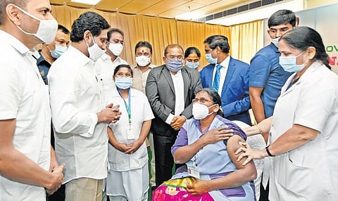 Andhra Pradesh CM YS Jagan Mohan Reddy interacts with B Pushpa Kumari, the firsthealth worker to get the Covid vaccine, at the GGH in Vijayawada. (Photo | EPS)