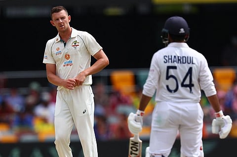 Australia's Josh Hazlewood (L) shares at India's batsman Shardul Thakur (R) on day three of the fourth cricket Test match. (Photo | AFP)