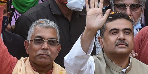 West Bengal BJP chief Dilip Ghosh (L) and Trinamool Congress turncoat Suvendu Adhikary wave at party activists during a roadshow in Kolkata. (Photo| PTI)