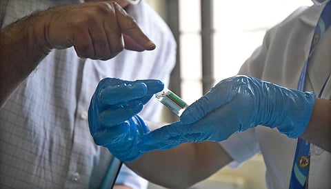 A medic shows a Covishield vaccine vial (Photo | Ashish Krishna, EPS)