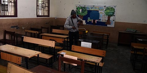 A worker seen spraying sanitizer at the school premises before the opening of classes for the 10th and 12th students in New Delhi. (Photo | Parveen Negi, EPS)