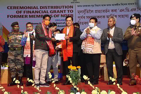 Assam CM Sarbananda Sonowal handing over the financial grant to an ex-NDFB cadre in Guwahati. (Photo | EPS)