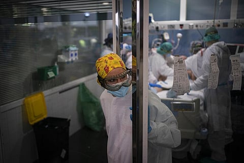 A health worker looks out from an ICU unit as a COVID-19 patient receives treatment in the Hospital del Mar, in Barcelona, Spain. (Photo | AP)
