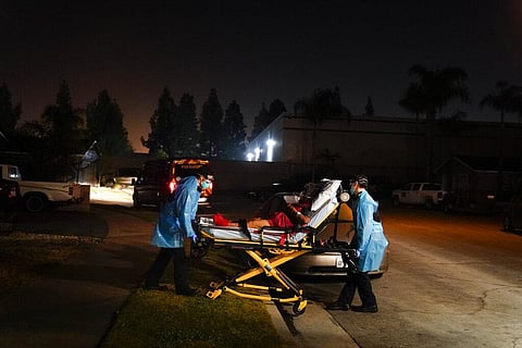 Emergency medical technicians Joshua Hammond, left, and Thomas Hoang, of Emergency Ambulance Service, transport a COVID-19 patient to an ambulance in California. (Photo | AP)