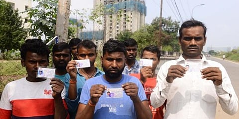 Migrant workers from UP and Bihar display their identity cards in front of the construction site where they work, at Mogappair in Chennai. (Photo| Debadatta Mallick, EPS)