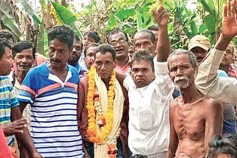 Garlanded Charan Palluar with residents of Phulhar at Birola village.