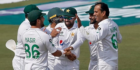Pakistan's Nauman Ali (R) celebrates with teammates after taking the wicket of South Africa's batsman Dean Elgar at the National Stadium, in Karachi. (Photo | AP)