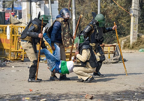 Security personnel detain a member of a group of people claiming to be locals, who reached the Singhu border protest site. (Photo| PTI)