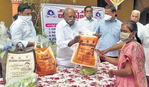 Retired principal Ramachandra Reddy distributing essential commodities to the needy in Kadapa I Express