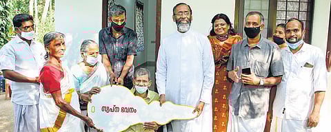 Fr Davis Chiramel handing over Raveendran the key to his house which was built by South Florida Kerala Samajam and American Malayalis | Express