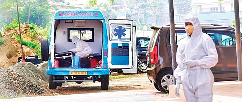 Salini P S, who is Covid positive, writing the PSC exam on the premises of her exam centre at Tripunithura in Ernakulam on Saturday. (Photo | EPS)