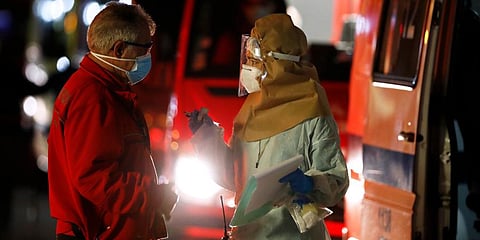 An hospital medic talks to an ambulance driver waiting in line to hand over their COVID-19 patients to medics at the Santa Maria hospital in Lisbon. (Photo | AP)