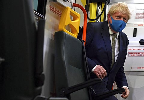 Britain's Prime Minister Boris Johnson, wearing a face mask, boards an ambulance during a visit to the headquarters of the London Ambulance Service NHS Trust in London. (Photo | AP)