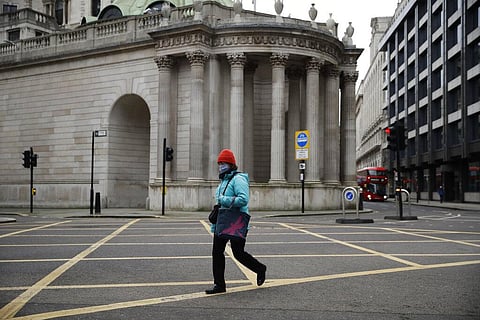 A woman walks past part of the Bank of England in the City of London financial district in London. (Photo | AP)