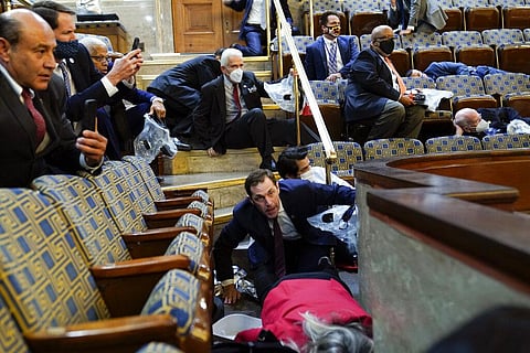 People shelter in the House gallery as protesters try to break into the House Chamber at the U.S. Capitol on Wednesday, Jan. 6, 2021, in Washington. | AP
