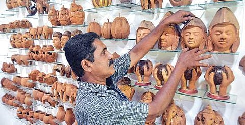An artist at the Arts and Crafts Village is seen arranging his work made of coconut husks
