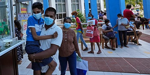A man carries a boy who will be administered the COVID-19 vaccine in Colombo, Sri Lanka. (Photo | AP)