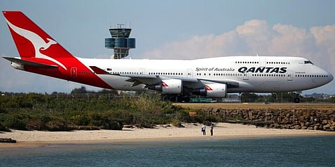 People watch from a beach as a Qantas plane taxies on the runway at Sydney Airport. (File Photo | AP)