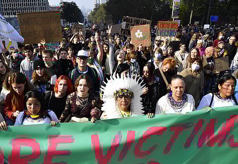 People hold signs and banners as they participate in a climate march and demonstration in Brussels, Sunday, Oct. 10, 2021. (Photo | AP)
