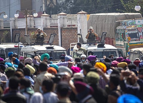 Indian policemen on top of their vehicles record with their cameras as Sikh community members block the road during the funeral procession of slain Satinder Kaur in Srinagar. (Photo | AP)