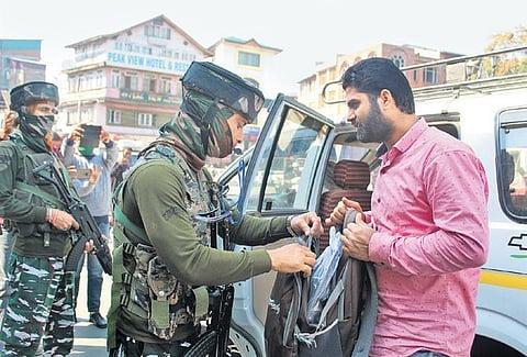Security personnel frisking commuters in Srinagar on Saturday. (Photo | Zahoor Punjabi)