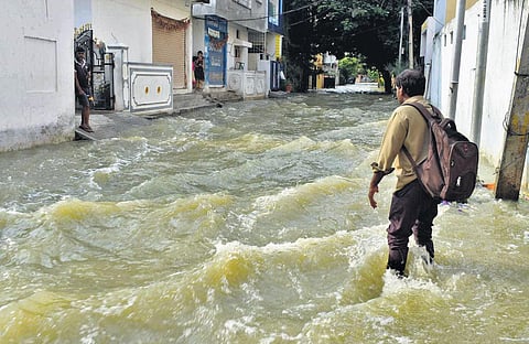 A man wades through a submerged road at Sisala Basti near Dilsukhnagar, on Saturday |VINAY MADAPU
