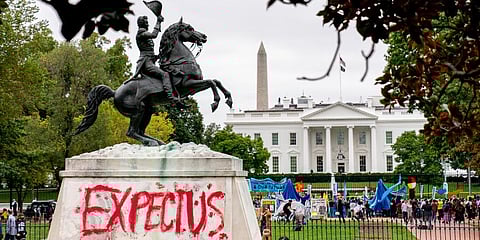 The words 'Expect Us' are spray painted on the base of the Andrew Jackson statue in Lafayette Park as Indigenous and environmental activists protest in front of the White House. (Photo | AP)