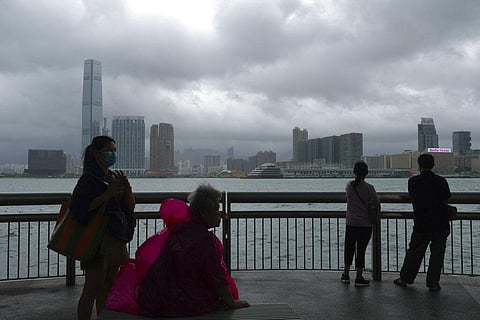 People stand against Victoria Habour as Typhoon Kompasu passes in Hong Kong Wednesday, Oct. 13, 2021. (Photo | AP)