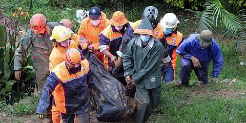 Rescuers carry the body of a victim caught in a landslide caused by Tropical Storm Kompasu in Baguio city, northern Philippines. (Photo | AP)
