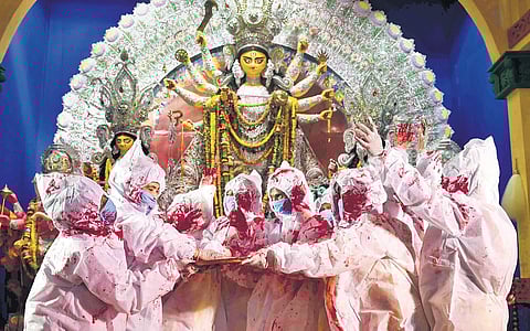 Devotees in PPE kits bid goodbye to Goddess Durga on the final day of Puja festivities in Kolkata on Friday | PTI