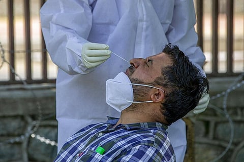 A health worker takes a nasal swab sample of a man. (File photo| AP)