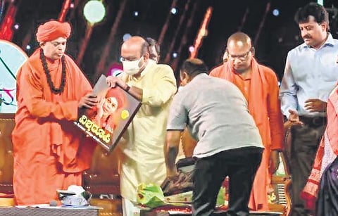 Chief Minister Basavaraj Bommai releases the coffee table book ‘Vishwaroopi Dr Shivamurthy Murugha Sharanaru’, brought out by The New Indian Express, in Chitradurga on Monday. Dr Shivamurthy Murugha S
