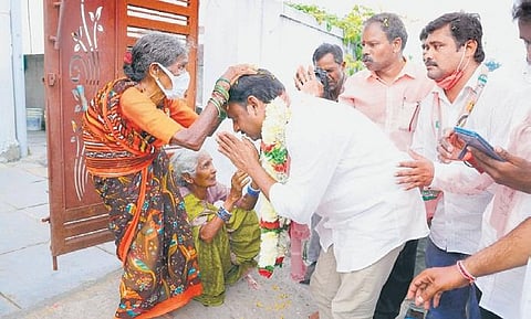 TRS candidate Gellu Srinivas Yadav seeks blessings from an elderly woman, during his election campaign in Huzurabad on Friday