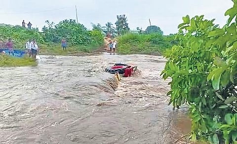 A tractor gets carried away by the strong water current while crossing the low-level bridge at Srikonda mandal in Nizamabad district on Friday